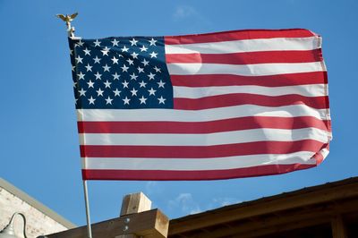 Low angle view of flag against blue sky