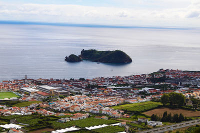 High angle view of townscape by sea against sky