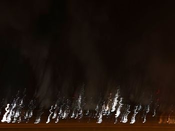 Low angle view of illuminated fountain against sky at night