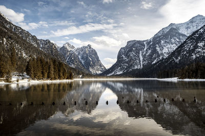 Scenic view of lake by snowcapped mountains against sky