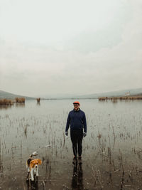 Man standing in water against sky