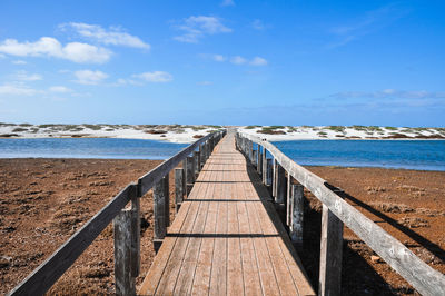 View of wooden pier on beach against sky