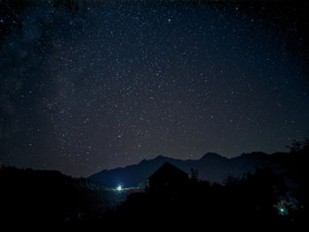 Silhouette mountains against sky at night