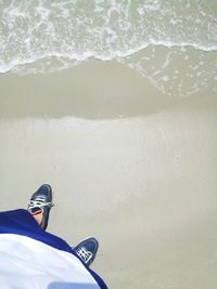 Low section of man standing in sea