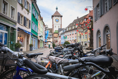 Bicycles parked on street amidst buildings in city