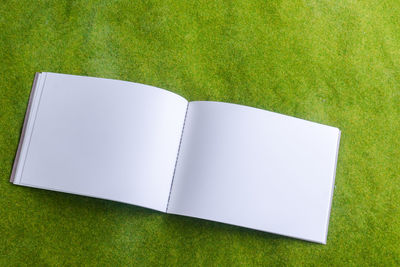 Directly above shot of open notebook on grass