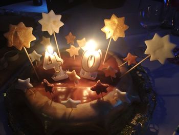 High angle view of lit candles on birthday cake