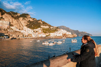 Side view of woman looking at sea against clear sky