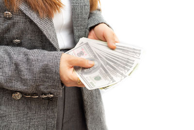 Midsection of woman holding camera against white background