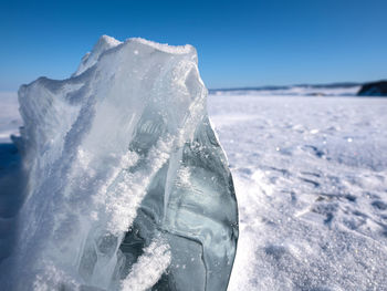 Close-up of ice crystals on land against sea