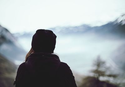 Rear view of woman standing against sky