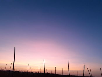 Silhouette of wind turbines against sky during sunset