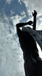 Low angle view of human hand against sky