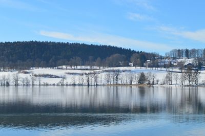 Scenic view of lake against sky during winter