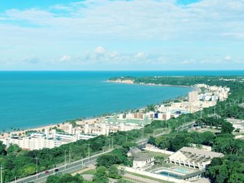 High angle view of cityscape by sea against sky