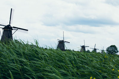 Traditional windmill on field against sky