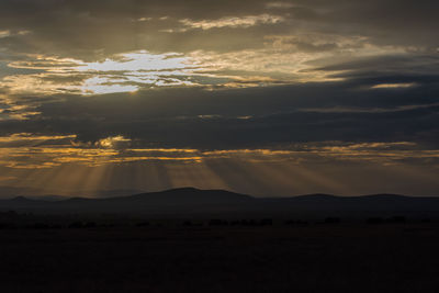 Scenic view of silhouette mountains against sky at sunset