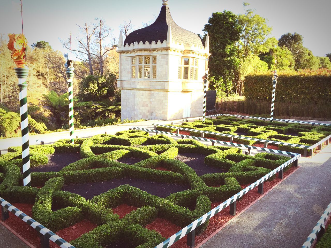 building exterior, architecture, built structure, tree, religion, plant, place of worship, sky, green color, day, growth, spirituality, outdoors, house, stone wall, formal garden, history, no people, church