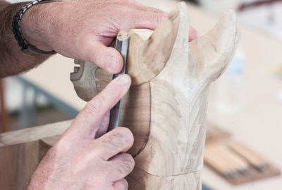 Cropped hands of man carving wood