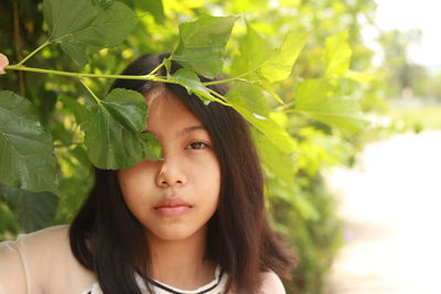 Portrait of woman with leaves outdoors