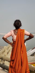 Rear view of woman looking at sea against sky