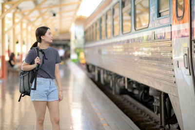 Full length of woman standing at railroad station