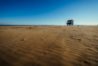 Scenic view of beach against clear blue sky