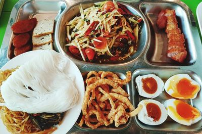 Variety of asian food served in metal plate at restaurant