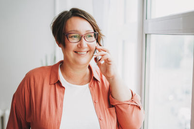 Portrait of smiling young woman using mobile phone