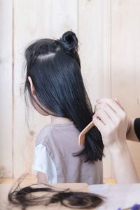 Cropped hands of hairdresser cutting hair at salon