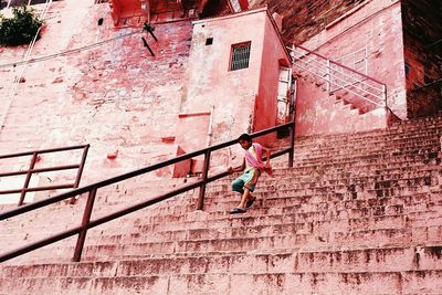 Low angle view of boy moving down on steps