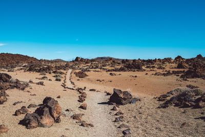 Scenic view of desert against clear blue sky