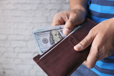 Man hand taking money out from wallet .