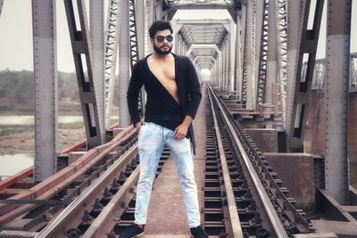 Portrait of young man standing on railroad tracks