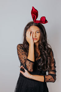 Portrait of beautiful woman standing against red background