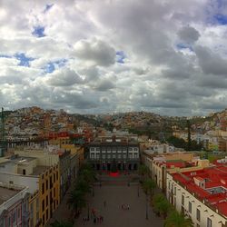 Buildings in town against cloudy sky