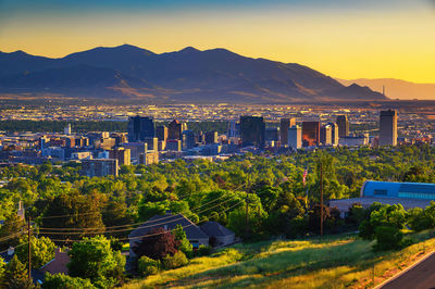 High angle view of townscape and mountains against sky during sunset