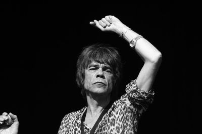 Portrait of woman with cigarette against black background