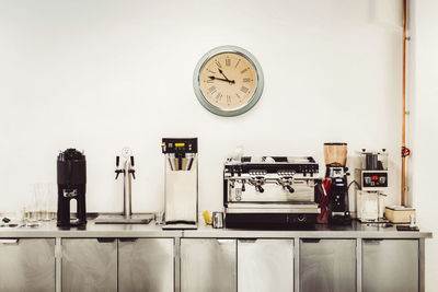 Olika kaffemaskiner och klocka i servering