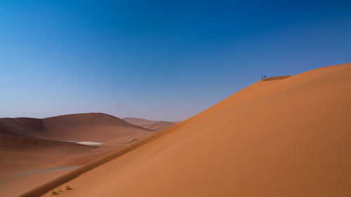 Scenic view of desert against clear blue sky