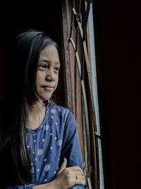 Portrait of a girl looking away in front of the window