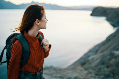 Side view of young woman looking at sea