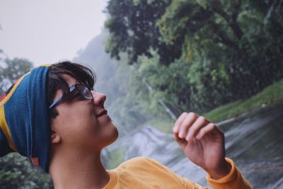 Close-up of young man standing on wet road during rainy season