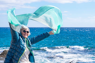 Portrait of woman standing in sea against sky