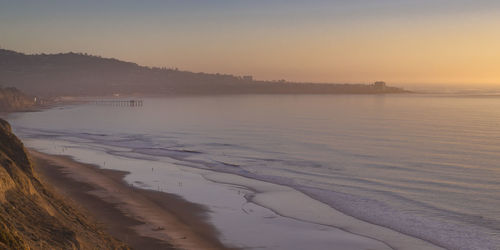 Scenic view of beach against sky during sunset