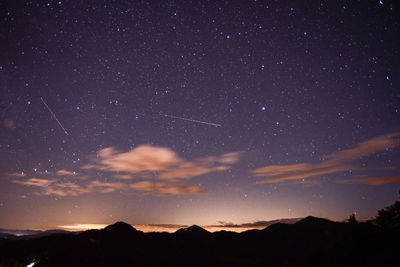 Scenic view of silhouette mountains against sky at night