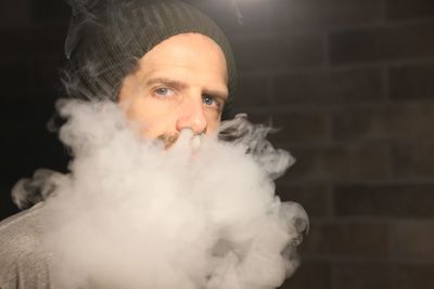 Portrait of man smoking in darkroom