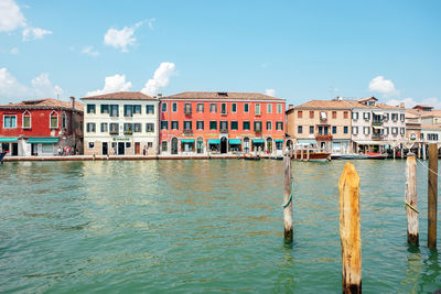 Houses by sea against sky in city