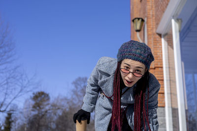 Portrait of young woman standing against sky