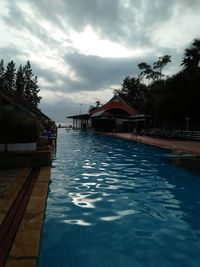 View of swimming pool by building against sky